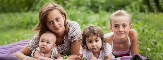 Mother with baby holding hands to face