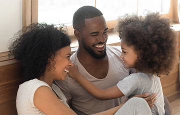 Male and female adult with small child sitting